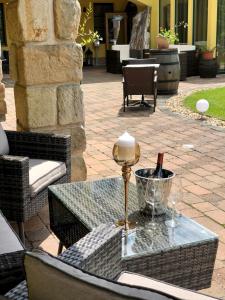 a glass table with a lamp on a patio at Hotel Garni Klaret in Valtice
