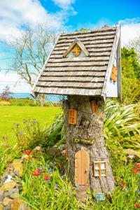 a small house on a tree stump in a field at BallyCairn House in Larne