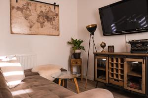 a living room with a couch and a flat screen tv at Ferienhaus Neuseenland in Großzössen