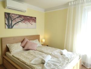 1 dormitorio con 1 cama con 2 toallas en NEST2 Apartments, en Keszthely