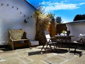a patio with a table and chairs next to a building at Courtyard Cottage in Filey