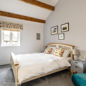 a bedroom with a large white bed and a window at Old Hall Croft Barn in Skipton