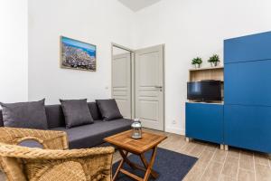 - un salon avec un canapé bleu et une table dans l'établissement L'Ilot I - Hyper centre Marseille Vieux Port, à Marseille