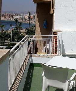 una mesa blanca y una silla en el balcón en Estudio La Colonia, en Águilas