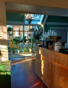 a restaurant with a counter with a lot of plants at Hotel De Gravin van Vorden in Vorden
