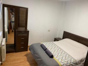 une chambre avec un lit, une commode et un miroir dans l'établissement Apartamento low cost, à Gijón