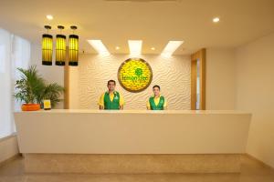 钱德加尔Lemon Tree Hotel Chandigarh的两名男子站在大厅柜台后面