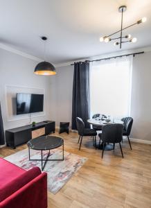 a living room with a red couch and a table at Słone Residence Apartamenty & Beer SPA in Kudowa-Zdrój