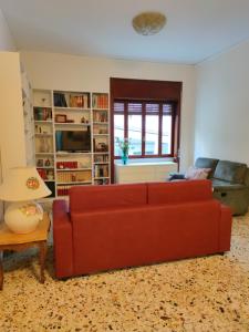 a living room with a red couch and a table at CASA VACANZE "A casa di Maria" in Naples +26 photos