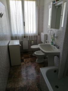 uma casa de banho com 2 WC, um lavatório e uma banheira em Appartamento con Giardino em Levanto