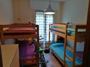 a room with three bunk beds and a bike in it at Appartamento con Giardino in Levanto
