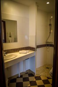 ein Bad mit einem Waschbecken und einem Spiegel in der Unterkunft Brit Hotel Azur in Saint-André-de-la-Marche