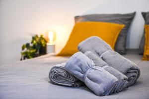 una pila de toallas sentadas encima de una cama en Le Duplex - Terrasse au cœur de Marseille Panier, en Marsella
