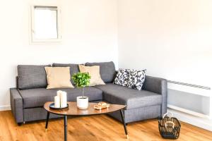 a living room with a gray couch and a table at Le Duplex - Terrasse au cœur de Marseille Panier in Marseille