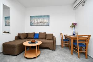 a living room with a couch and a table at apartmani Novotny- žuti in Rab