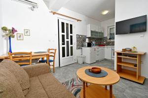 a living room with a couch and a table at apartmani Novotny- žuti in Rab
