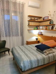 a bedroom with a bed and a chair and a window at CASA VACANZE "A casa di Maria" in Naples