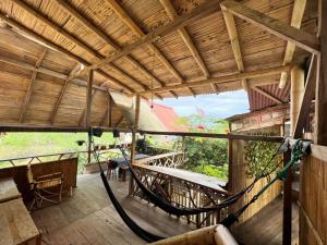 eine Veranda eines Hauses mit einer Hängematte darauf in der Unterkunft hostal Monte Libano in Puerto López