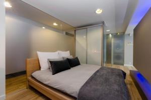 a bedroom with a large bed with white sheets and black pillows at LupoApartments Kosynierów Dostęp na Kod in Łódź