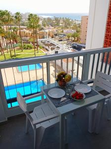 une table avec un bol de fruits sur un balcon dans l'établissement Playa de las Americas Seaview Viñadelmar, à Playa de las Americas