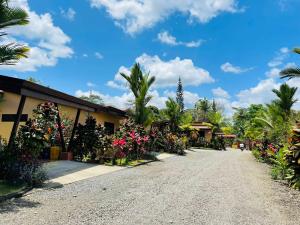 a street in a resort with flowers and palm trees at Aunty Arenal Lodge in Fortuna