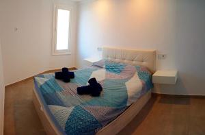 une chambre avec un lit avec deux chaussures dessus dans l'établissement Playa de las Americas Seaview Viñadelmar, à Playa de las Americas