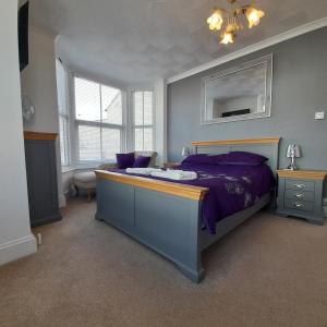 a bedroom with a bed with a purple comforter at BERNARDS HIDEOUT in Cromer