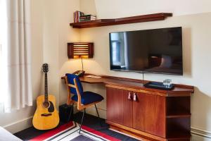 a living room with a tv and a guitar at Freehand Chicago in Chicago