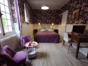 a bedroom with a bed and a desk and a piano at Le Coin des Artistes in Giverny