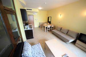 a living room with a couch and a table at Menada Midia Apartments in Sunny Beach