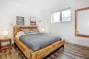 1 dormitorio con cama de madera y espejo en 05 Chemin des Cascades, en Stoneham