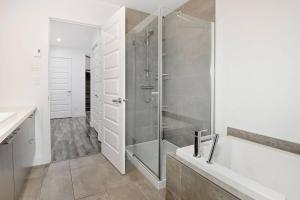 a bathroom with a shower and a bath tub at 05 Chemin des Cascades in Stoneham +18 photos
