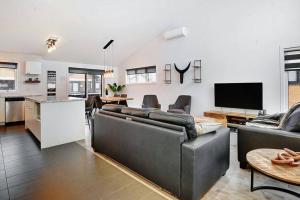 a living room with two couches and a kitchen at 05 Chemin des Cascades in Stoneham