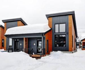 a house with snow on the ground in front of it at 05 Chemin des Cascades in Stoneham