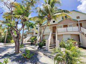 una casa con palmeras delante en Maracuja 4, Orient Bay village, walkable beach at 100m, en Orient Bay