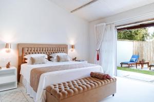 a white bedroom with a large bed and a couch at Pousada Boutique Coco Bambu Morere in Moreré