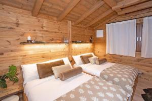 una camera con 2 letti in una baita di tronchi di iFlat Chalet Carole Ortisei a Ortisei