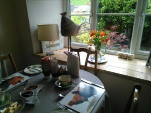 a kitchen table with a cat sitting on top of it at 2 Mill Cottages in Cornworthy