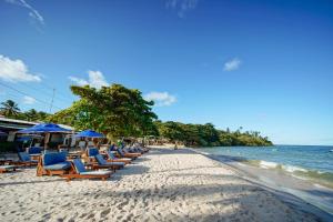 a beach with chairs and umbrellas and the ocean at Pousada Boutique Coco Bambu Morere in Moreré
