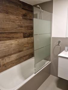 een badkamer met een douche en een houten muur bij Departamento Caleufu in Neuquén