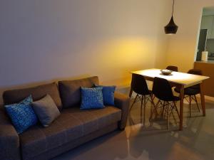 a living room with a couch and a table with chairs at Departamento Caleufu in Neuquén
