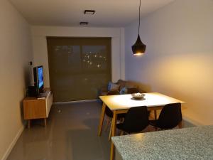 a living room with a table and a television at Departamento Caleufu in Neuquén