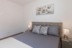 una camera da letto con un grande letto con cuscini blu di Peaceful Harmony Apartment Near Beach a Podstrana
