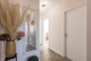 corridoio con specchio in una stanza bianca di Peaceful Harmony Apartment Near Beach a Podstrana