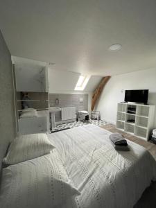 um quarto com uma grande cama branca num quarto em Maison de caractère em Crancey