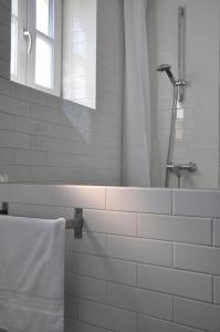 Best Rest Warszawa Stare Miasto في وارسو: حمام أبيض مع دش وحوض استحمام