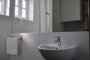 a white bathroom with a sink and a mirror at Best Rest Warszawa Stare Miasto in Warsaw