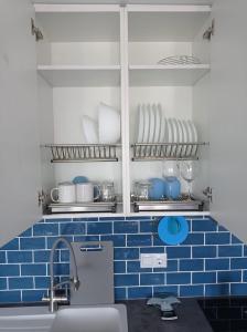 Il comprend une cuisine dotée de carrelage bleu sur le mur et d'un évier. dans l'établissement Playa de las Americas Seaview Viñadelmar, à Playa de las Americas