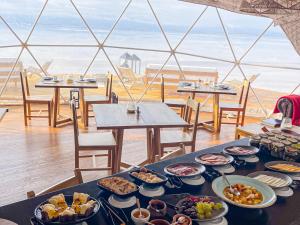 a table with plates of food on it with a view of the beach at Salinas Grandes Jujuy - Pristine Luxury Camp 