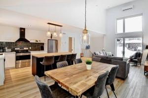 cocina y sala de estar con mesa de madera y sillas en 114 Chemin des Ruisselets, en Stoneham